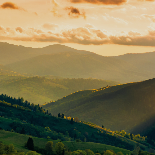 Omni Coffee Studio Banner. Picture of mountains in valleys during sunrise. Omni encourages self care and enjoying nature.